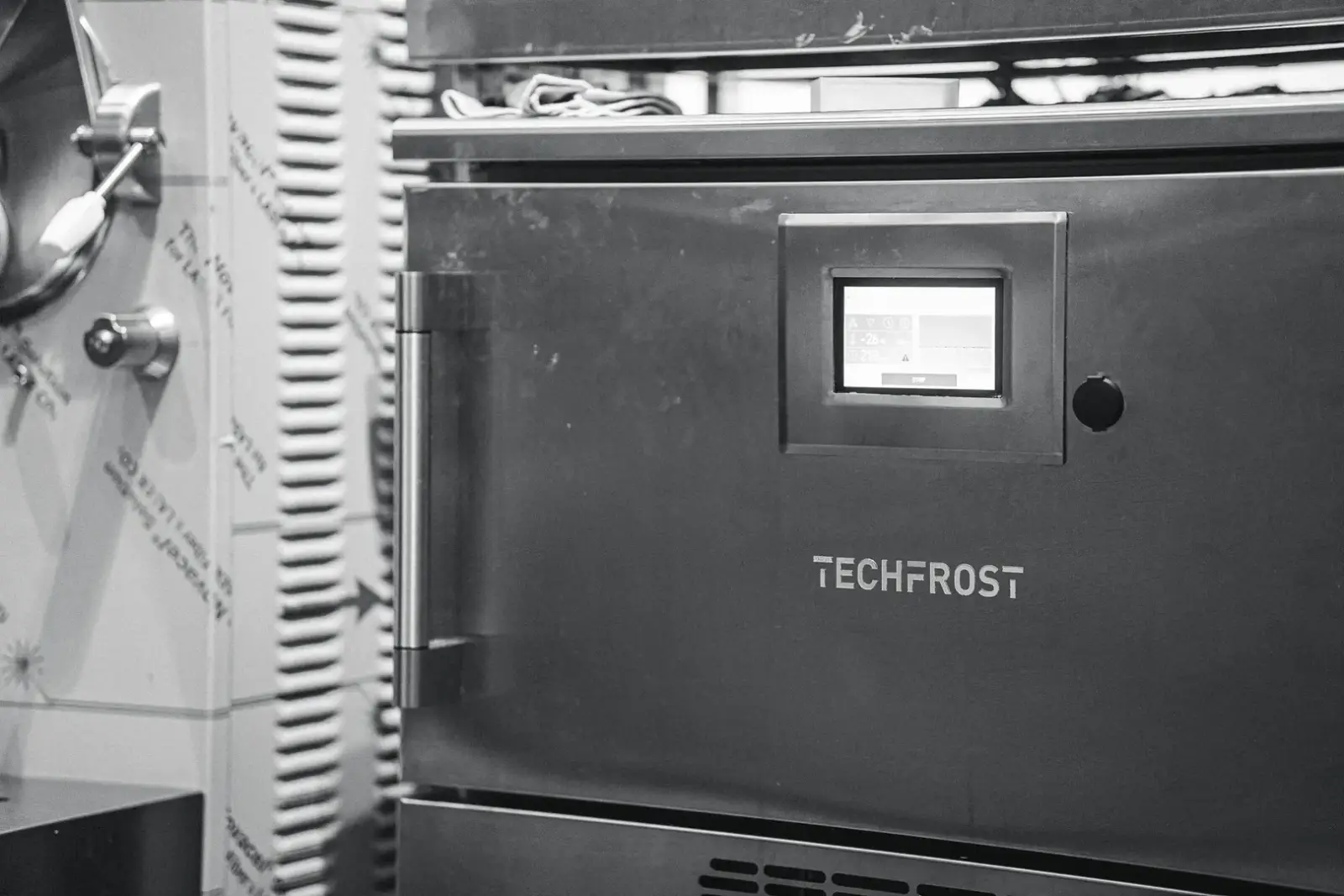 Close-up blast freezer Techfrost tampak depan dengan pintu terbuka, rak berisi produk makanan tersusun rapi